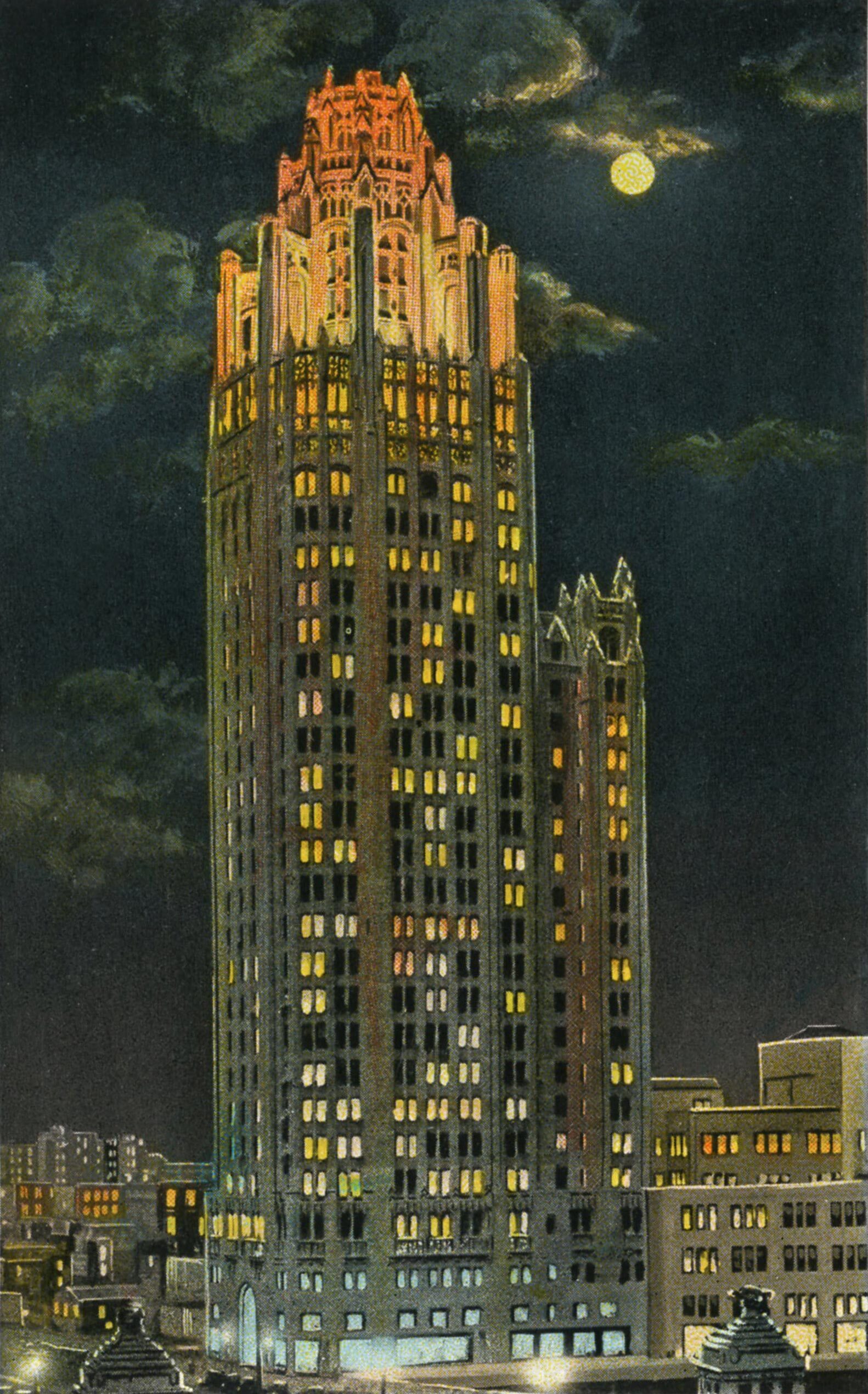 A color image of the Chicago Tribune Tower at night. A random pattern of the rectangular windows are illuminated from within and appear white and yellow in color. The uppermost portion of the building, the crown of gothic ornament and buttresses, is glowing in a bright red-orange color that stands out from the rest of the building. A glowing yellow full moon in the background illuminates scattered clouds.